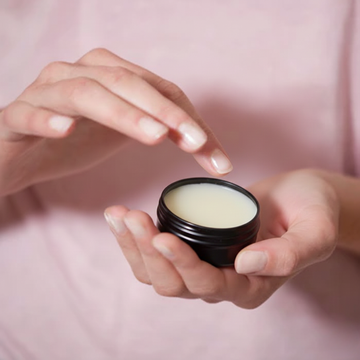 Applying solid perfume from compact jar